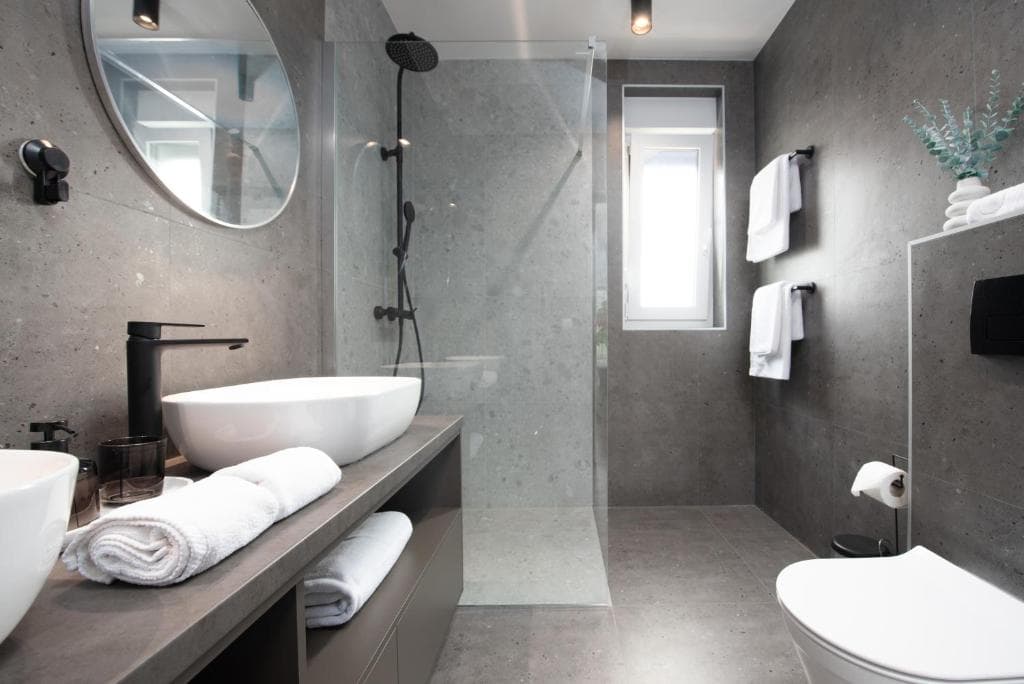 Bathroom with grey stone tiles and walk-in shower at Villa Maslina