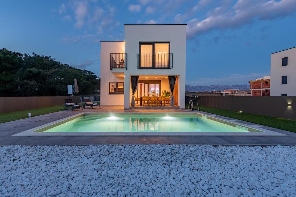 Villa Maslina illuminated at night with glowing pool